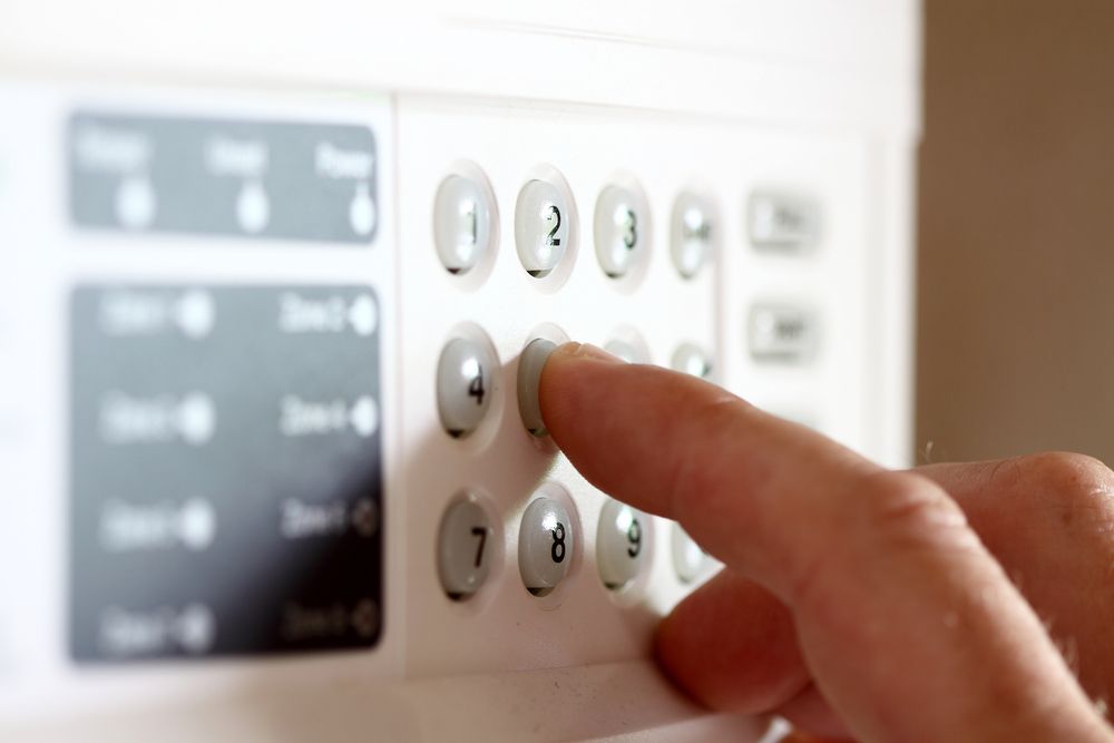 A Person is Pressing a Button on a Security System — Adept Security In Dapto, NSW