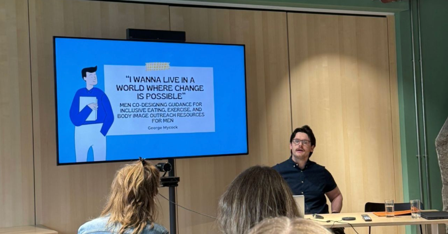 George presenting his PhD research on co-designing guidance for inclusive eating, exercise and body image outreach resources for men at the AEDRC