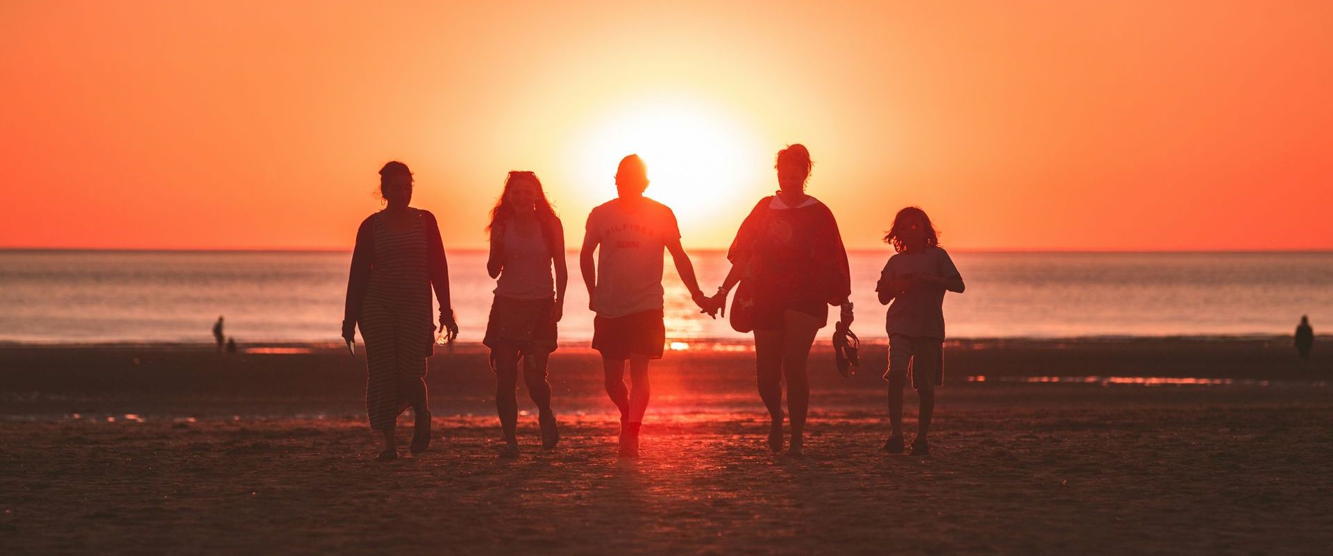 family walking into the sunset together