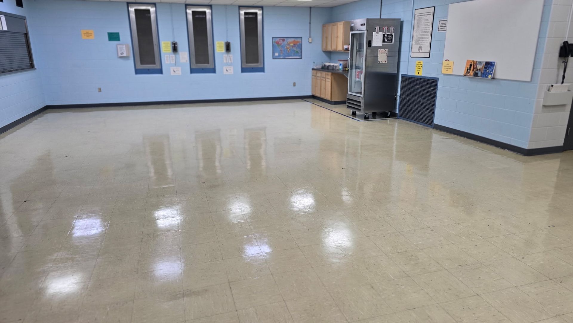Glossy tiled lobby floor with sunlight reflections and vertical glass or metal railings