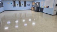 Glossy tiled lobby floor with sunlight reflections and vertical glass or metal railings