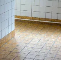Glossy tiled lobby floor with sunlight reflections and vertical glass or metal railings