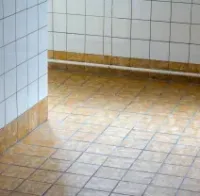 Glossy tiled lobby floor with sunlight reflections and vertical glass or metal railings