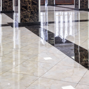Glossy tiled lobby floor with sunlight reflections and vertical glass or metal railings