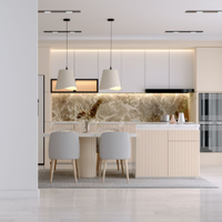 Modern white kitchen with island, pendant lights, beige chairs, and marble backsplash in a bright open space