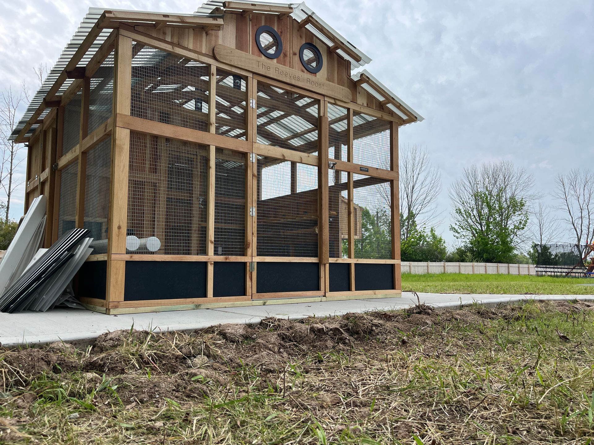A large house with a wooden deck and a grill in front of it.