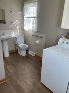 A large house with a wooden deck and a grill in front of it.