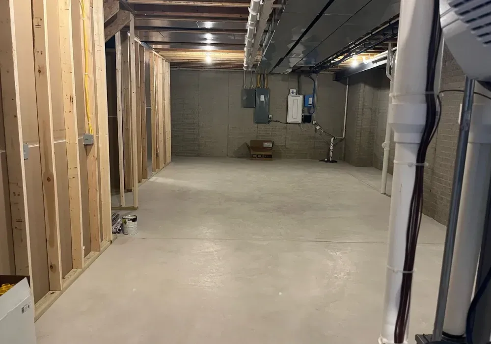 A basement under construction with a concrete floor and wooden walls.