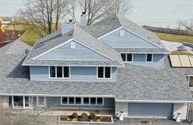 An aerial view of a large house with a gray roof.