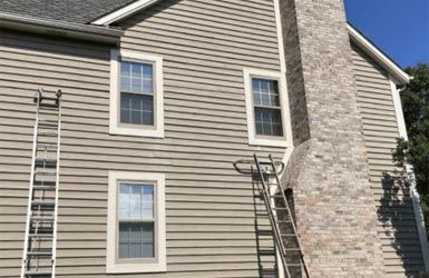 A house with a chimney and a ladder on the side of it.