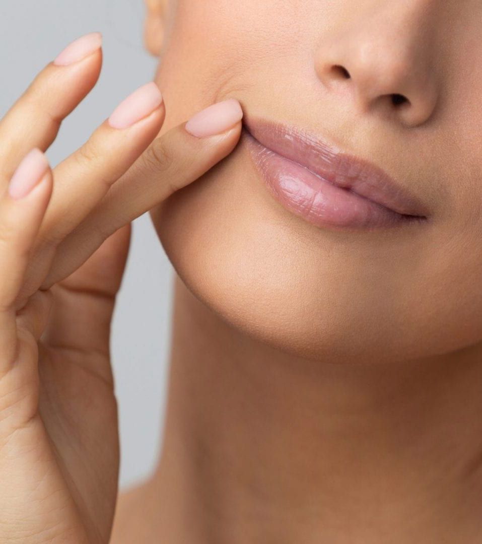 A close up of a woman's face with natural lip fillers.