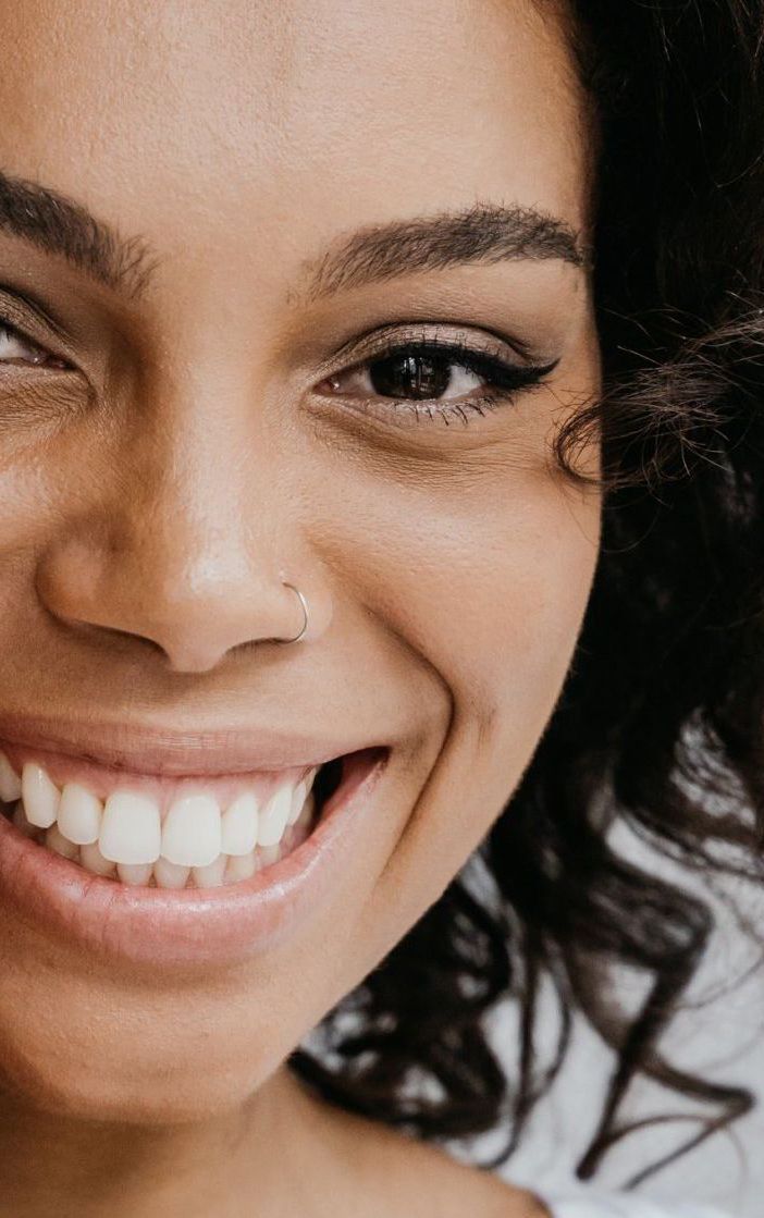 A close up of a woman 's face smiling.