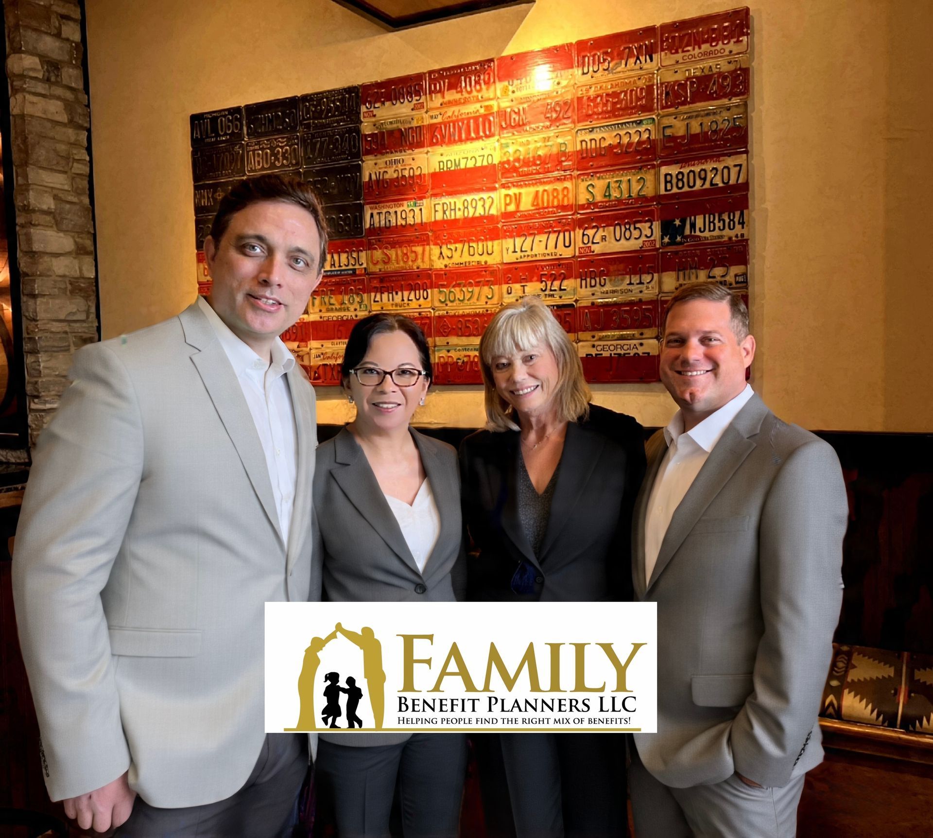 A man is sitting on a couch talking to two older people.