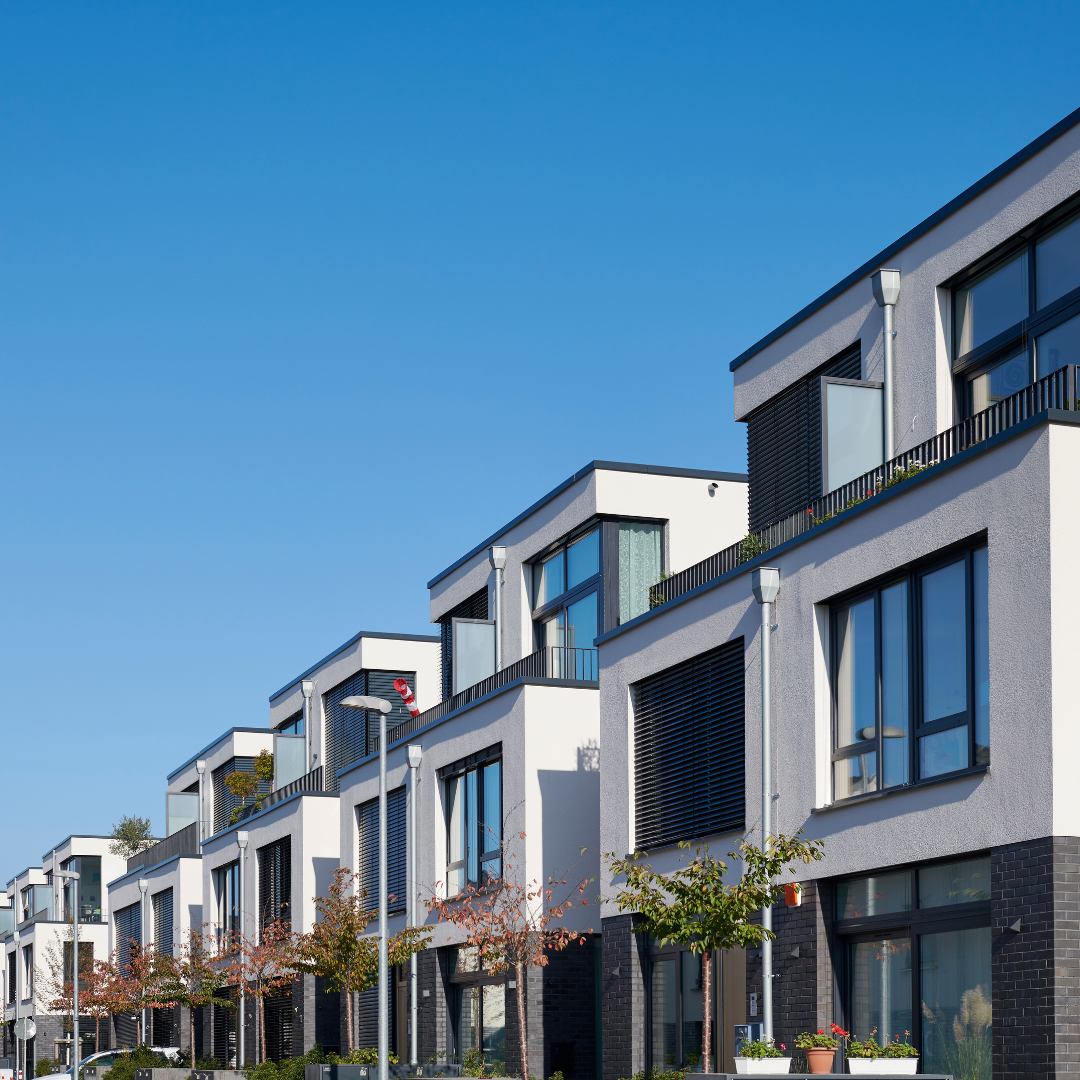 A row of houses with a blue sky in the background