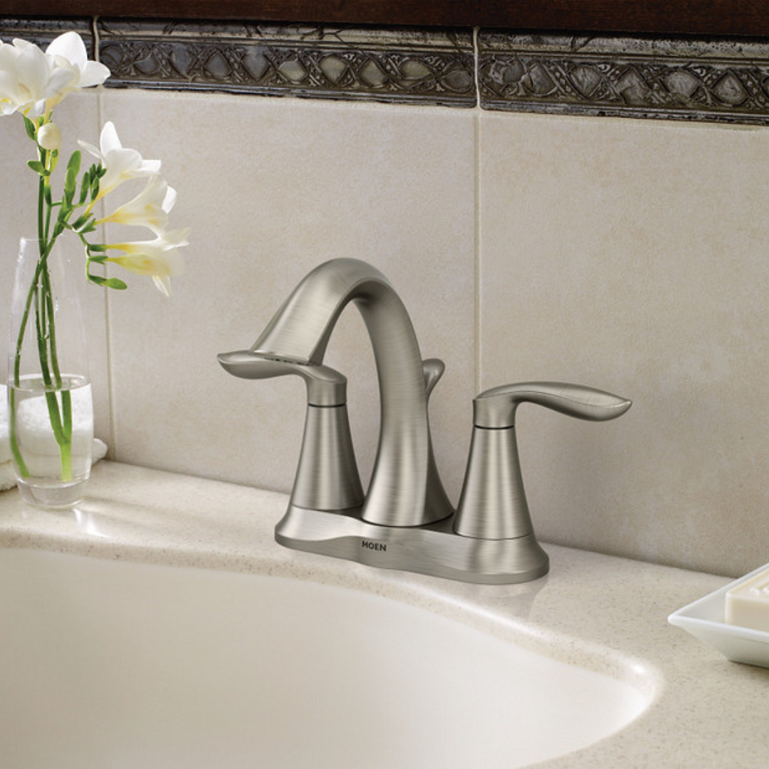 A bathroom sink with a faucet and a vase of flowers