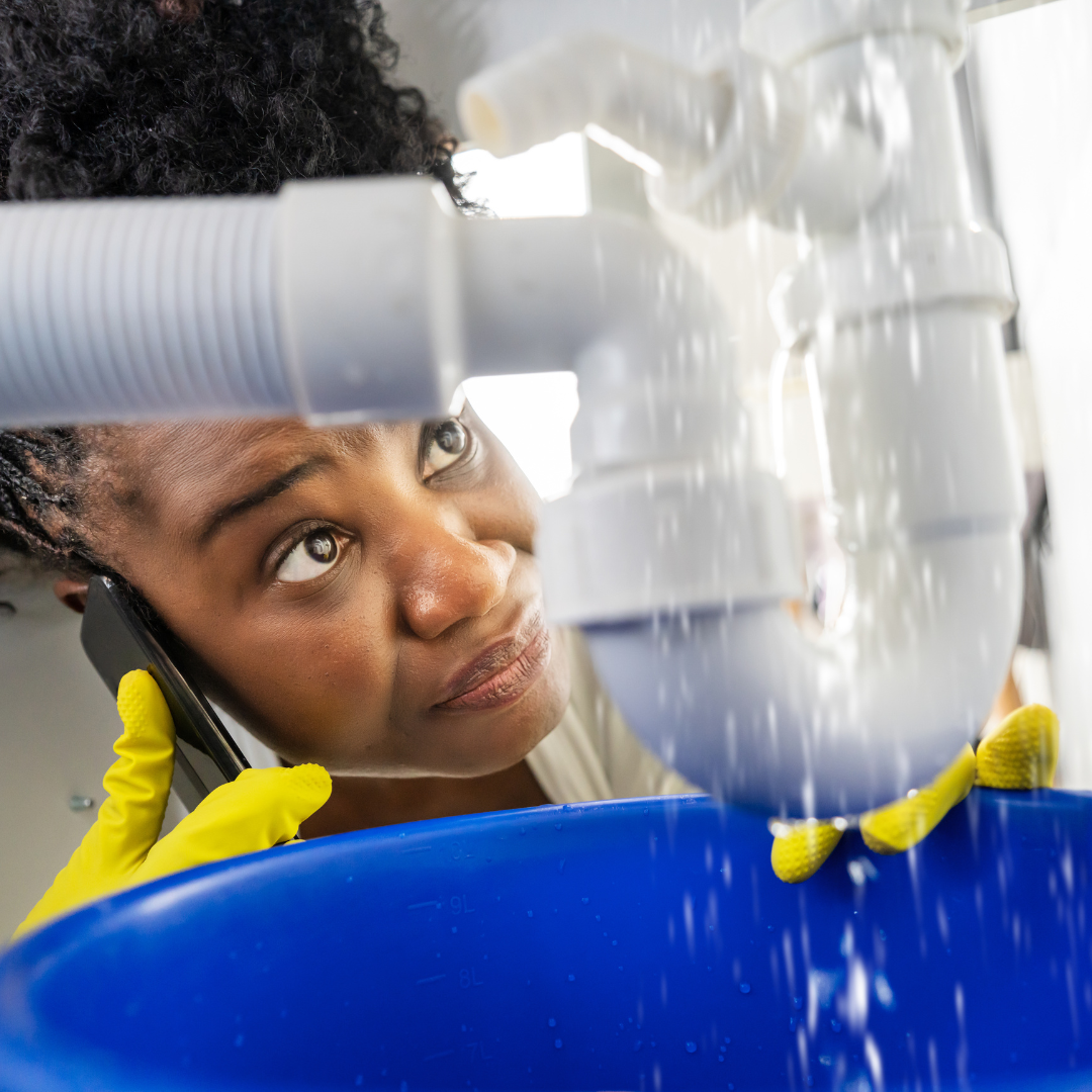 A woman is talking on a cell phone while holding a blue bucket.