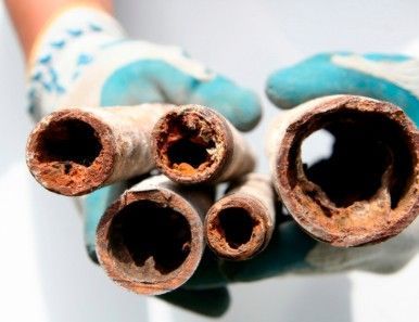 A close up of two rusty pipes stacked on top of each other.