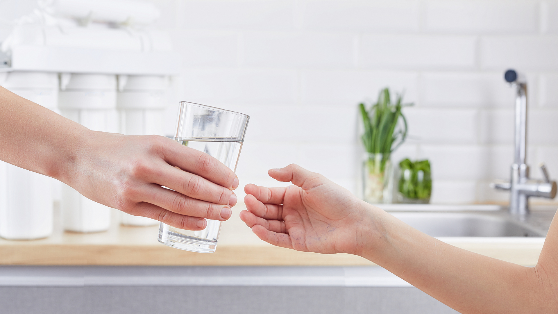 A person is giving a glass of water to another person.