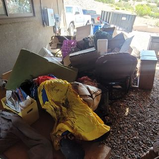 A pile of junk is sitting on the ground in a garage.