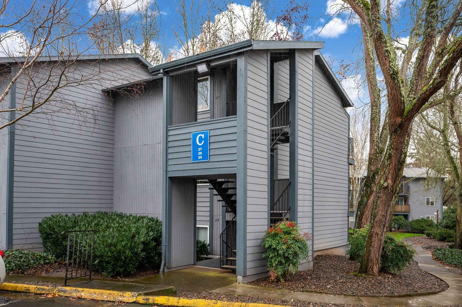 Gray apartment building with stairs and a