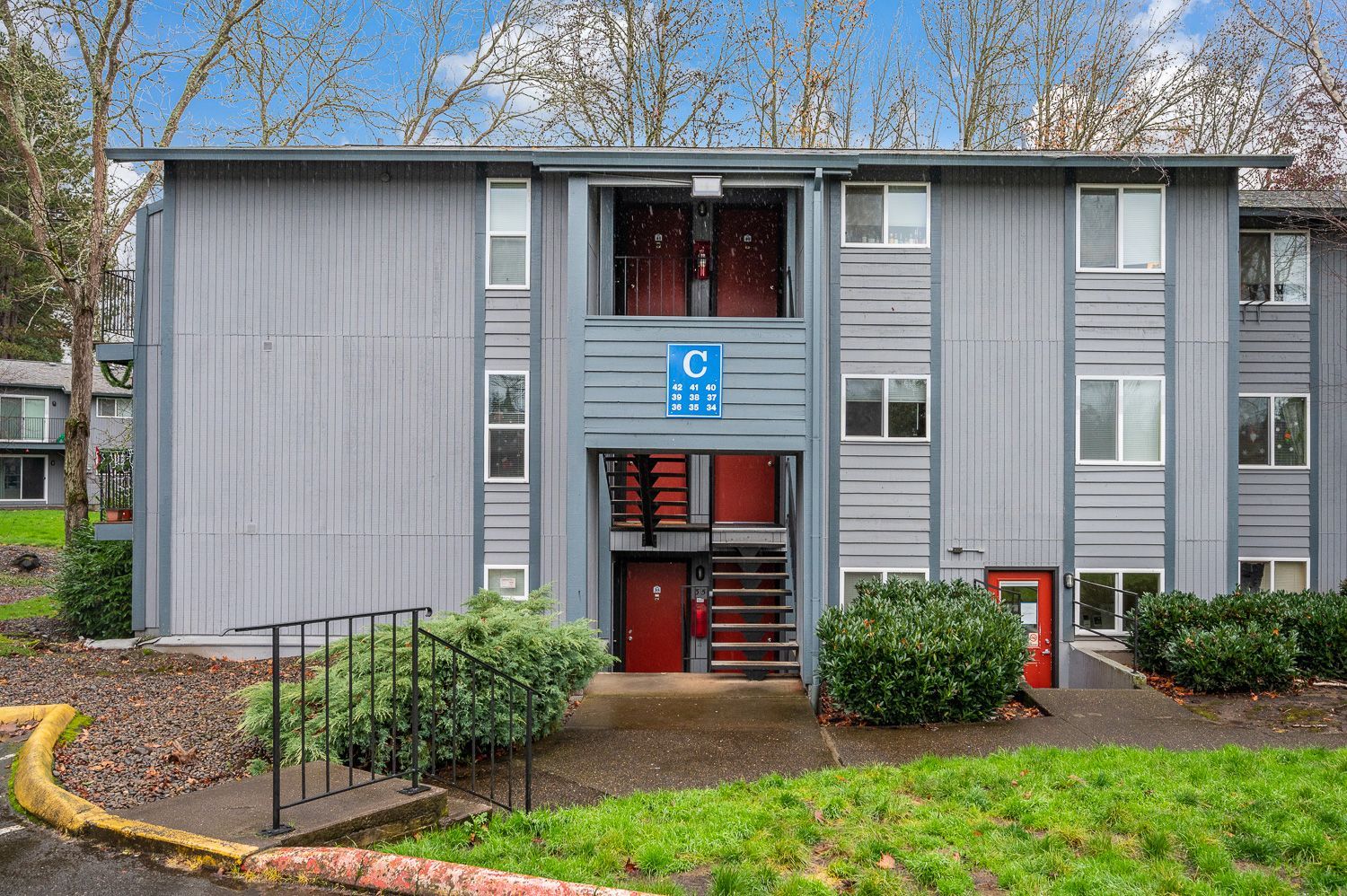 Gray apartment building with red doors,