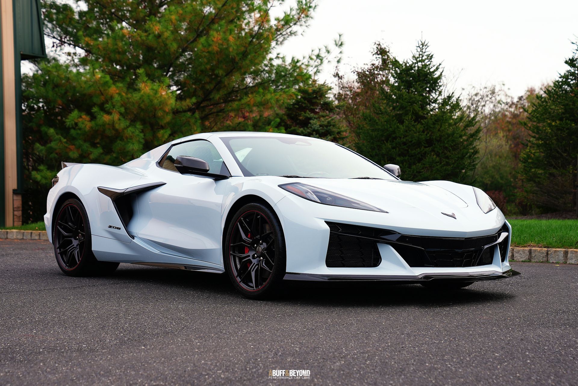 A white sports car is parked on the side of the road.