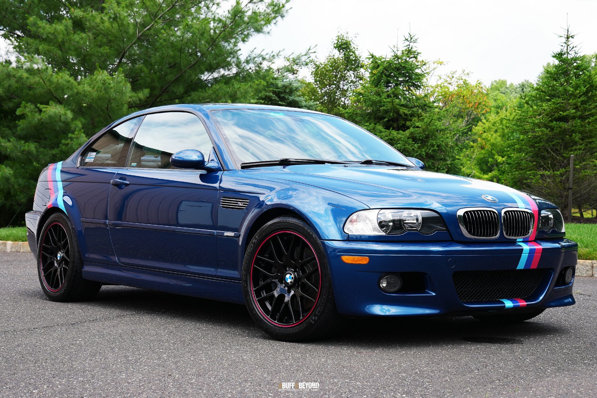 A blue bmw m3 is parked on the side of the road.