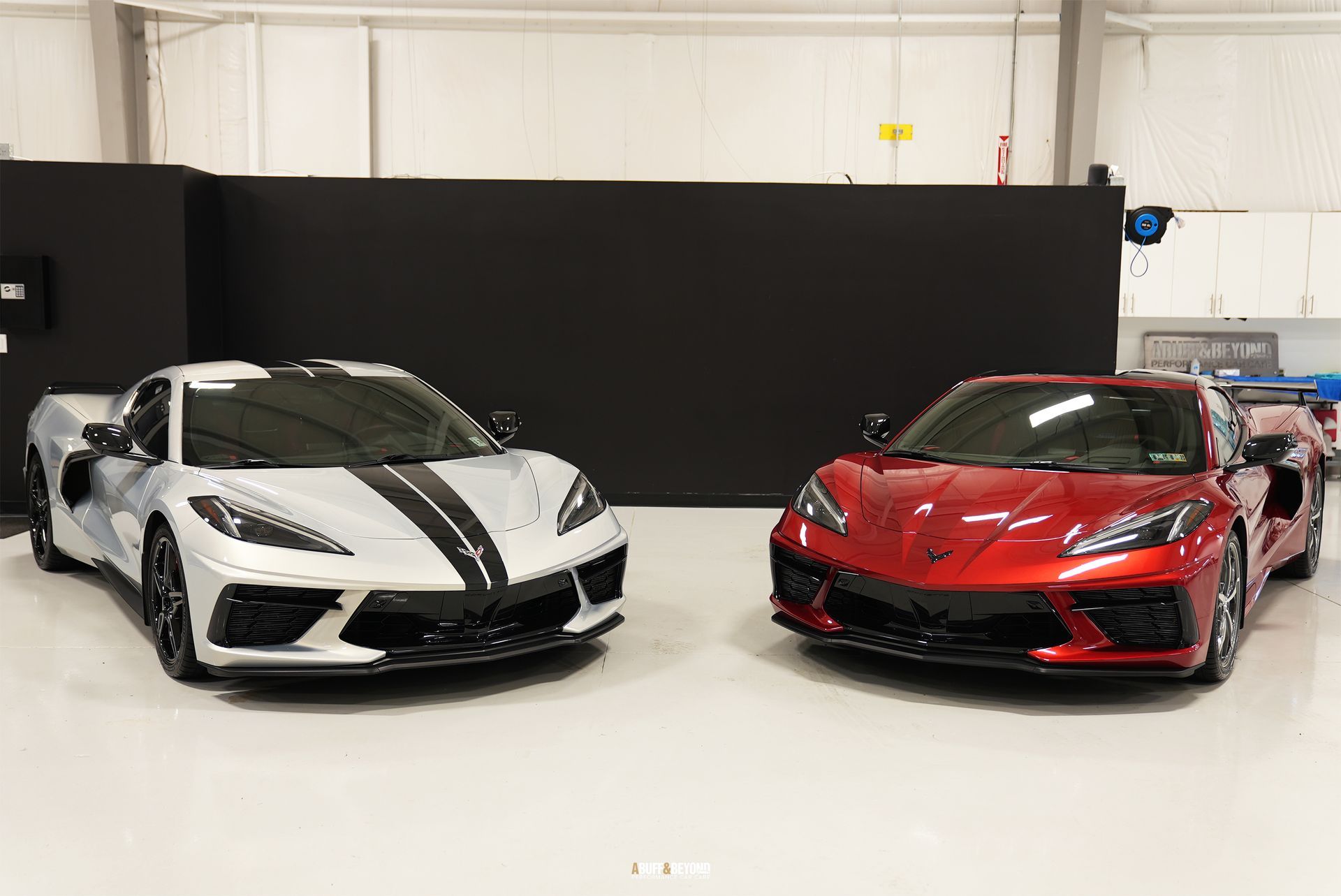 Two corvettes are parked next to each other in a showroom.