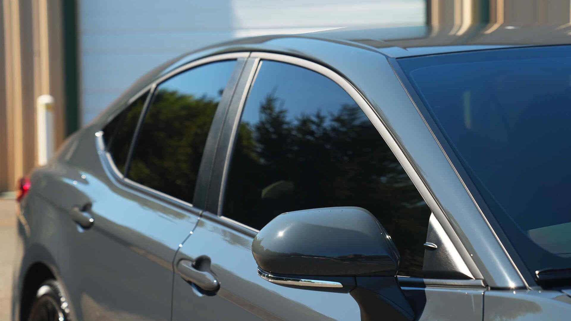 A silver car is parked in front of a building