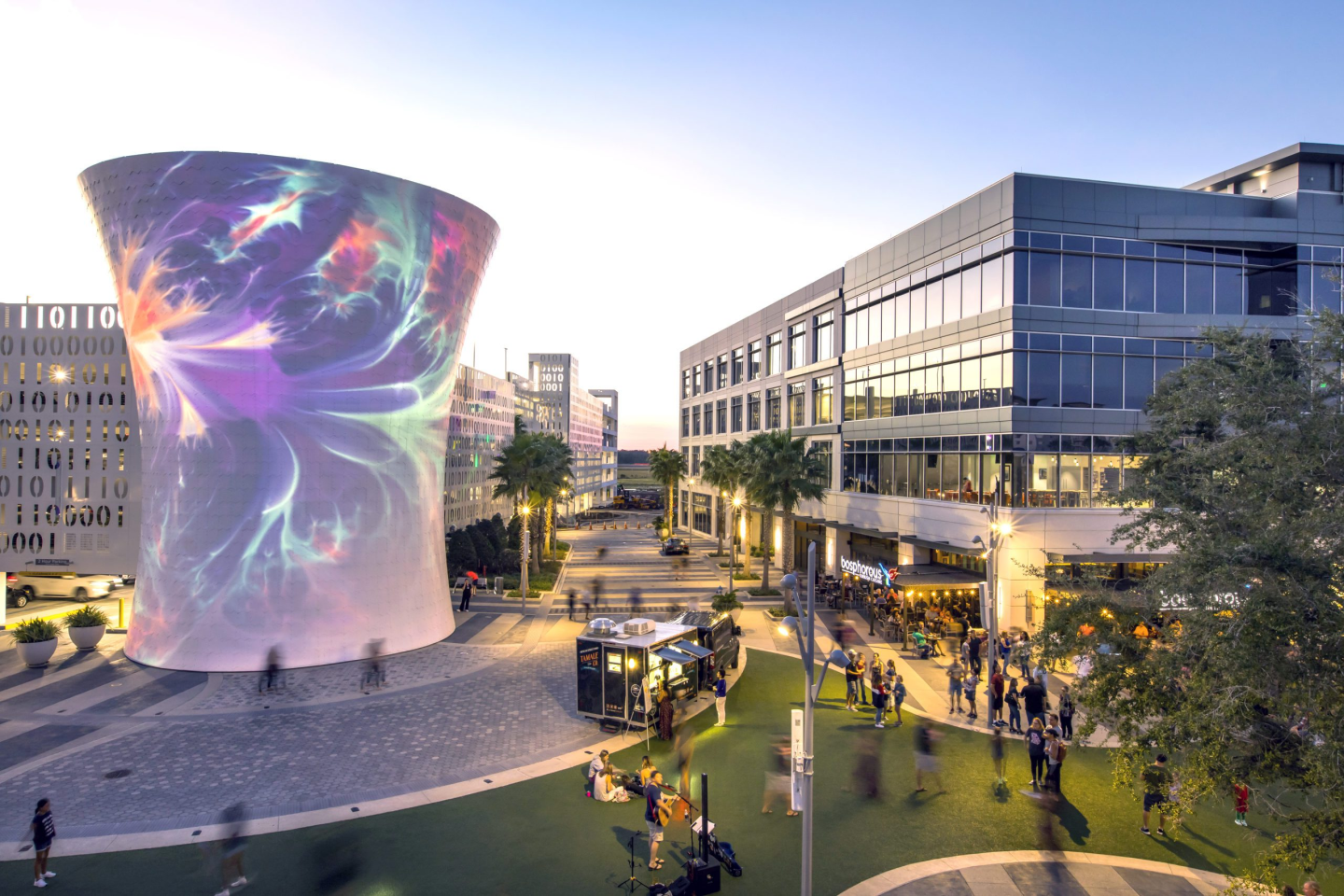 The las vegas sign is lit up at night with palm trees in the background.