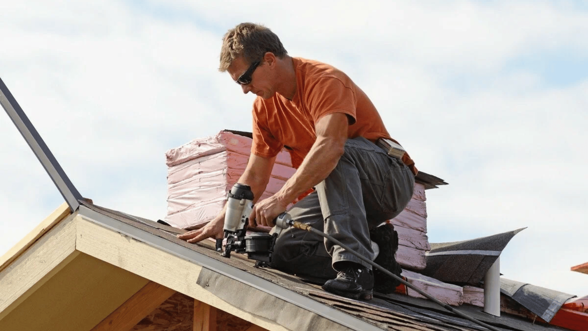 A man is working on the roof of a house.