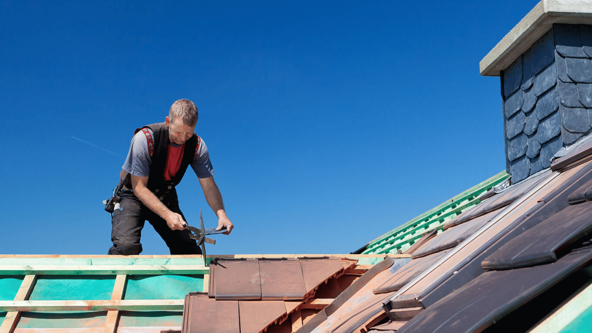 A man is working on the roof of a building.