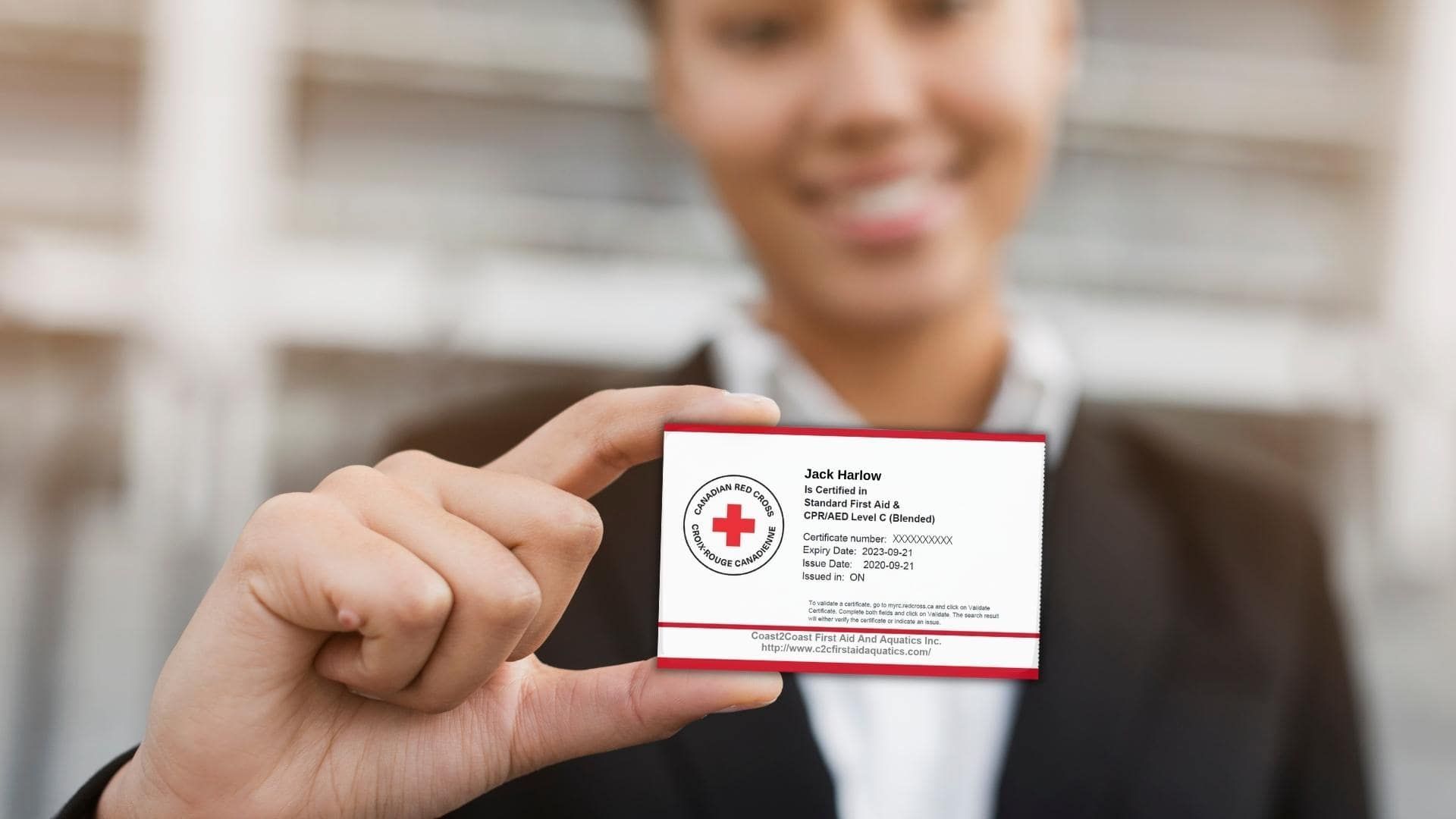 A woman is holding a business card with a red cross on it.
