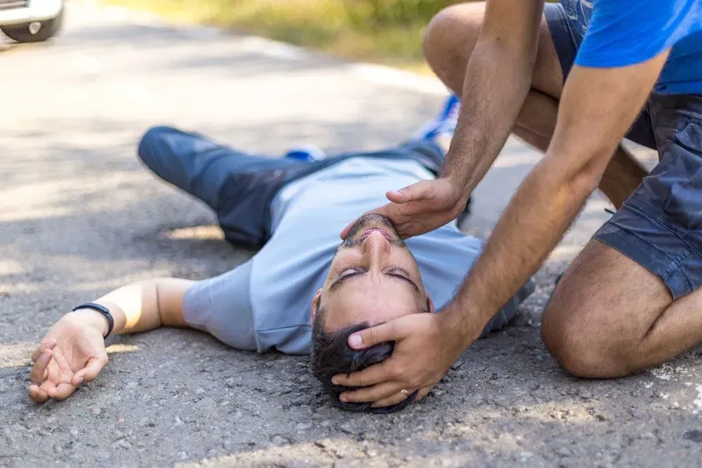 A man taking a picture of a man laying on the ground