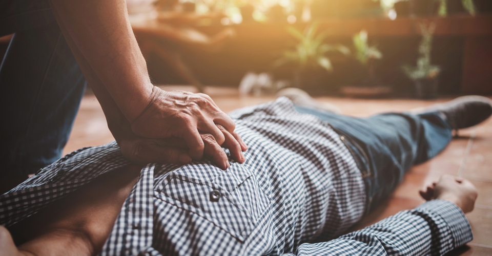 A man is laying on the floor with his hands on his chest.