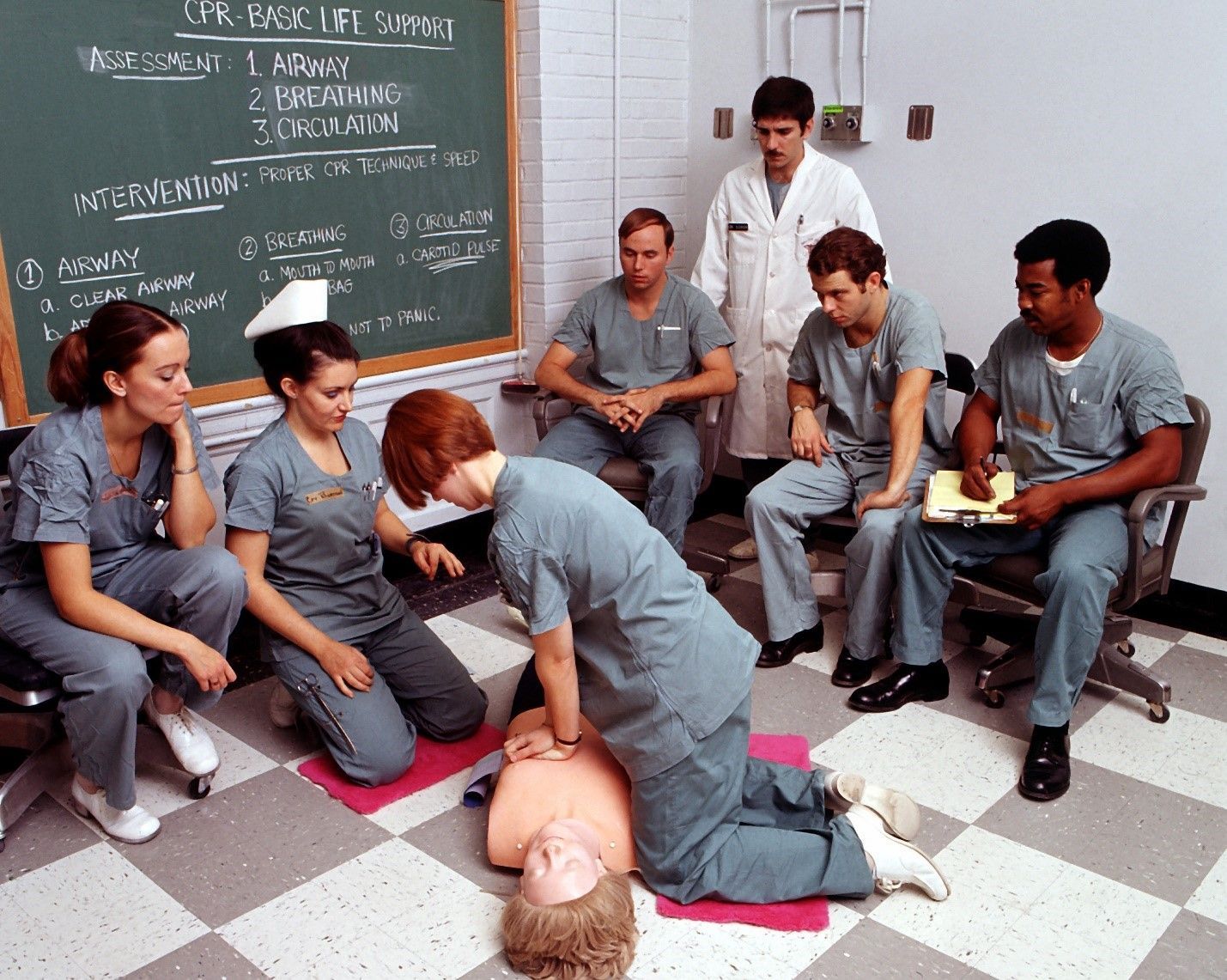 A group of nurses are practicing on a mannequin