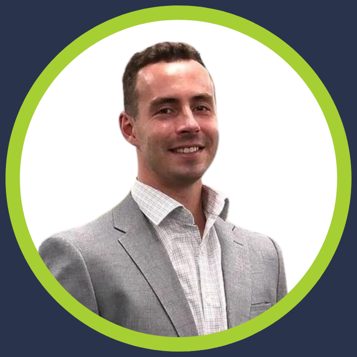 A man in a suit and white shirt is smiling in a green circle.