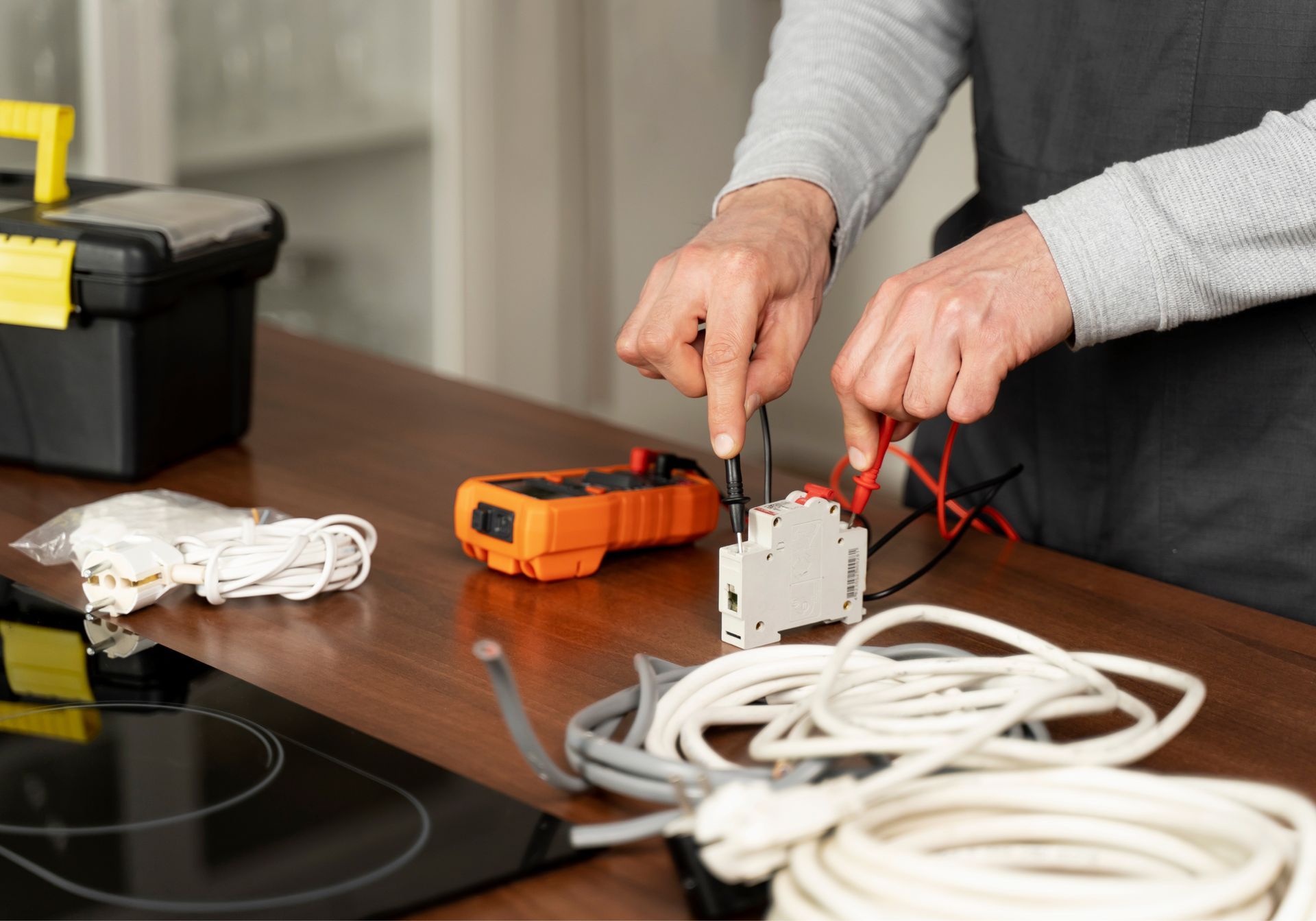 A person is working on electrical wires on a table.