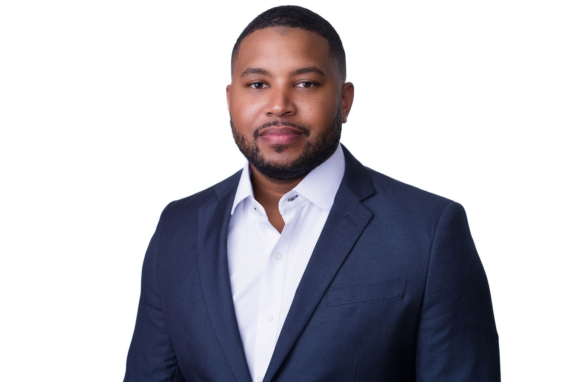 A bald man wearing glasses and a suit is looking at the camera in a black and white photo.