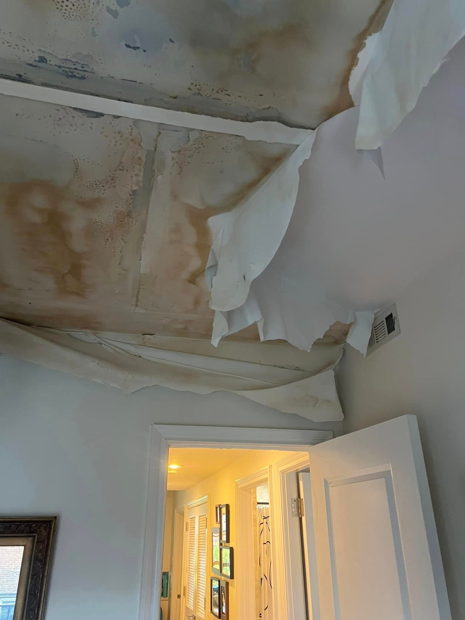 A room with a ceiling that has been damaged by water.