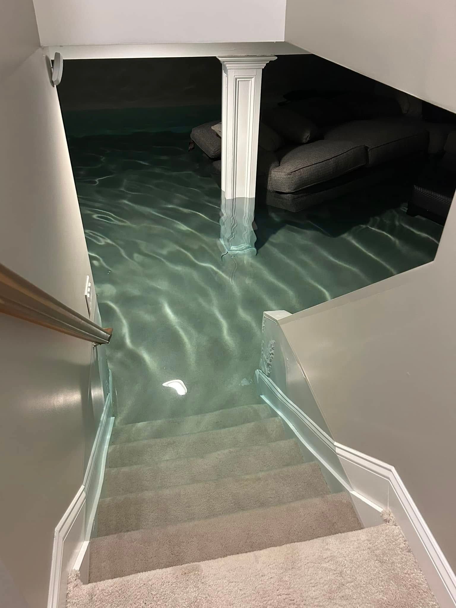 A flooded basement with stairs leading up to it