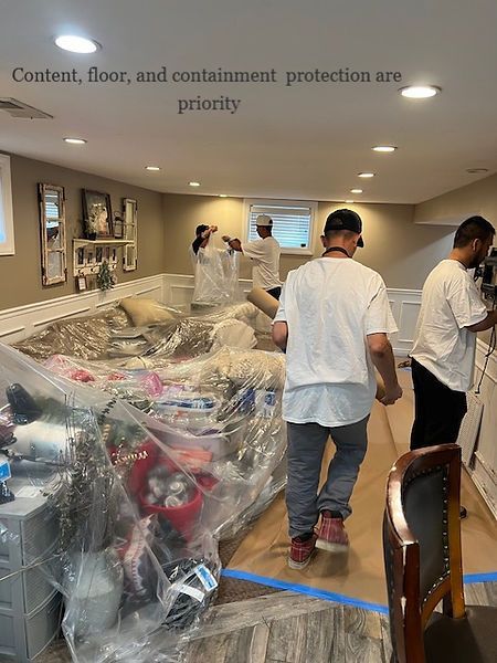 A group of men are standing in a living room covered in plastic.