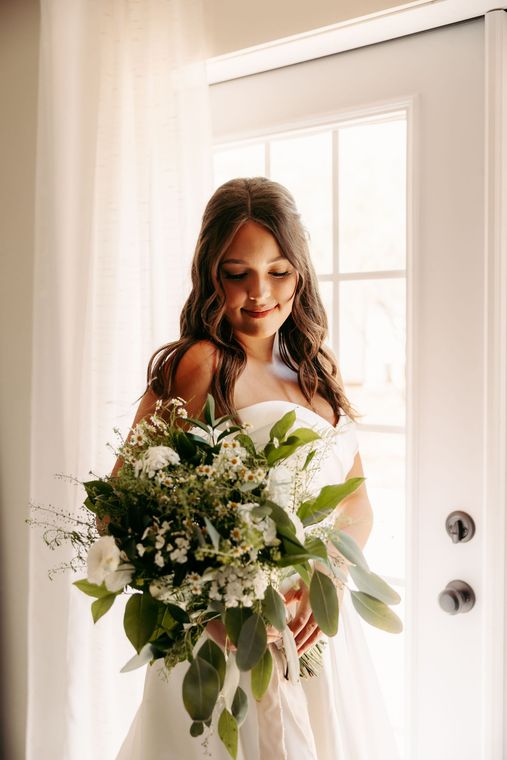 A woman is trying on a wedding dress in a bridal shop.