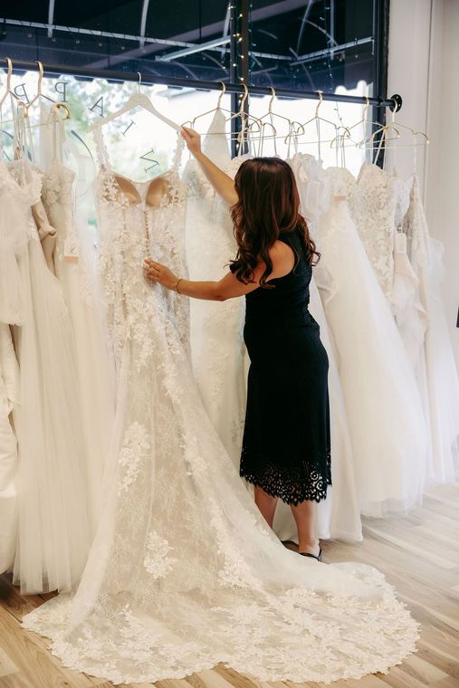 A woman is trying on a wedding dress in a bridal shop.