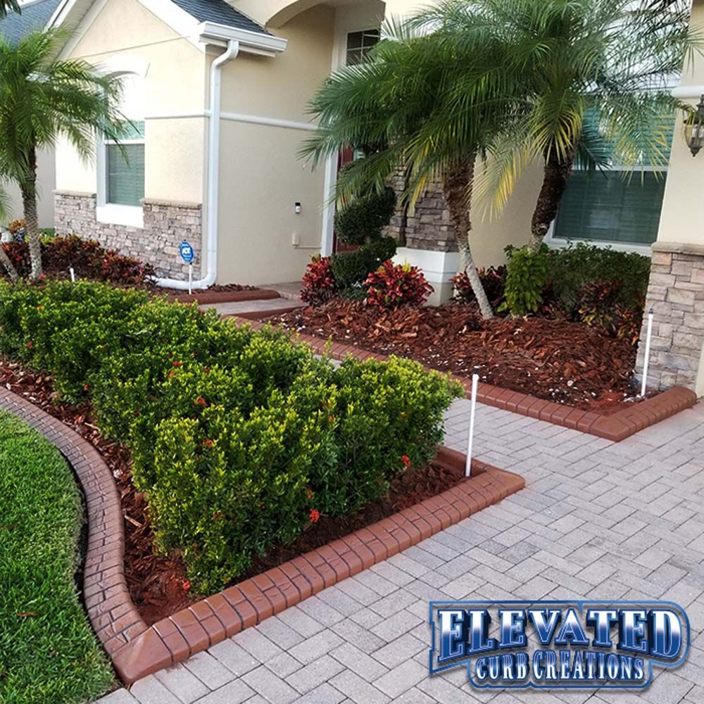 A house with a brick walkway and bushes in front of it