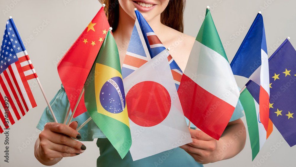 A woman holding colorful flags from various countries