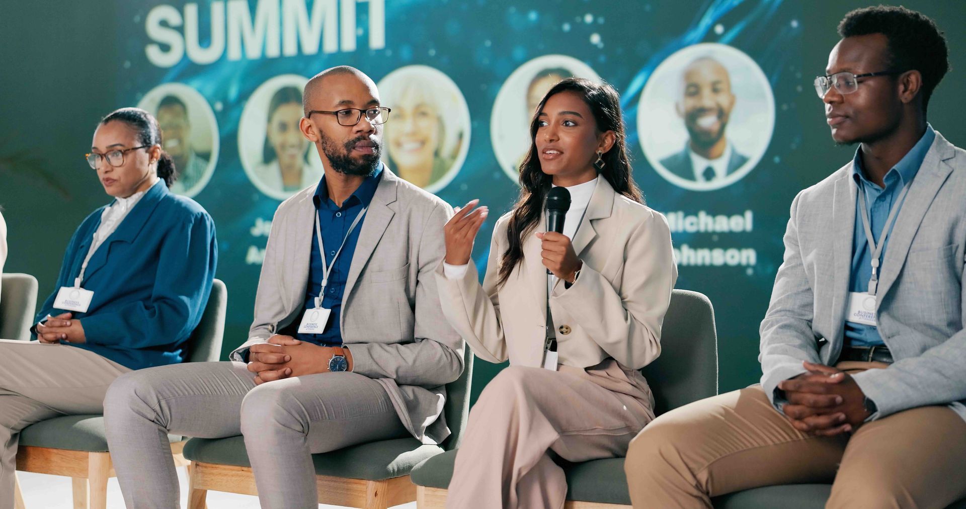 Panelists speaking to an audience from a stage during a hybrid event