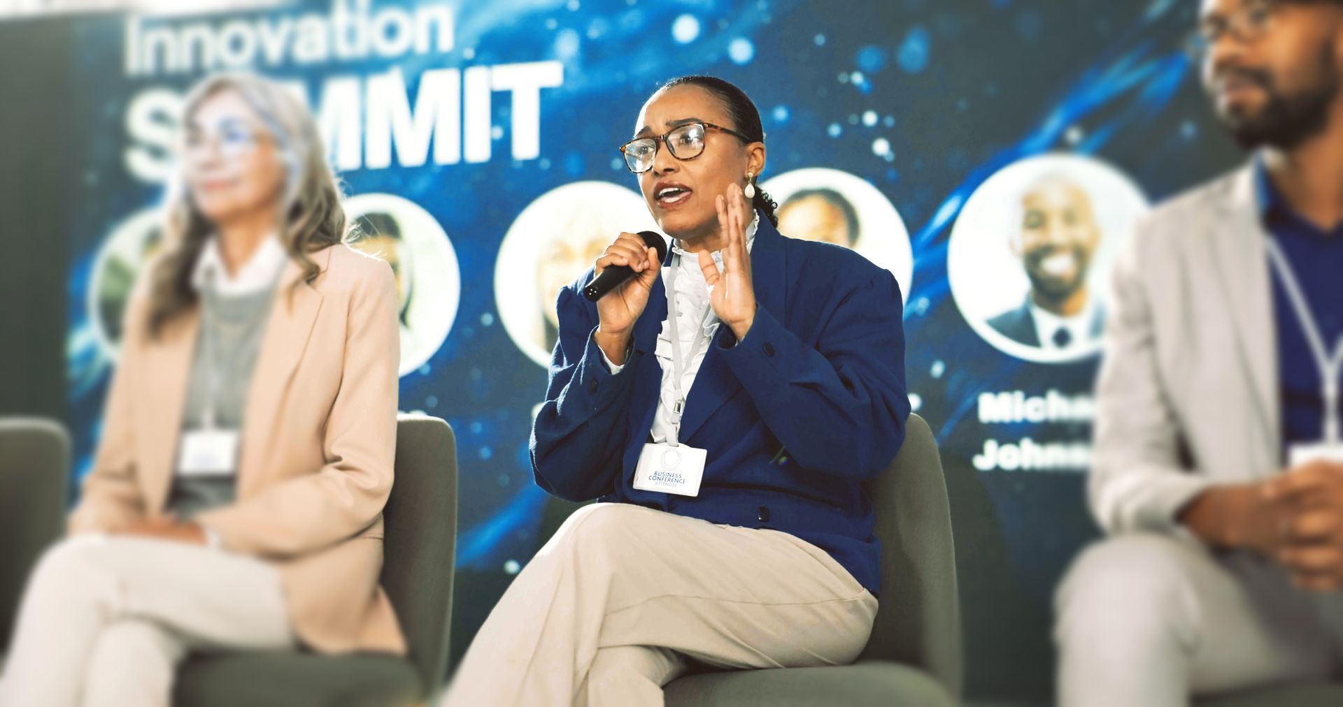 Panelists speaking to an audience from a stage during a hybrid event