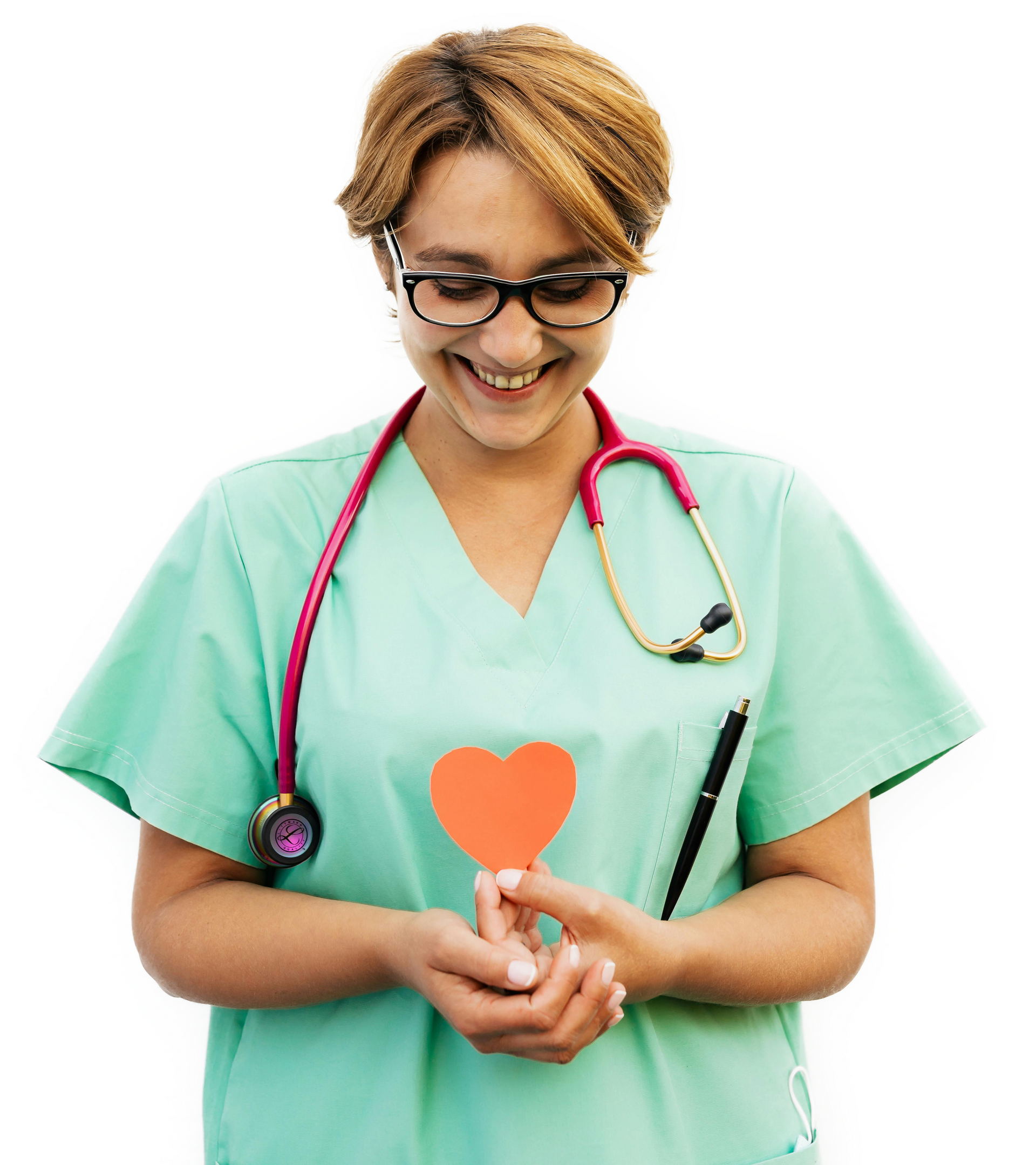 A smiling medical professional in green scrubs and a stethoscope holds a small orange paper heart against a white background.