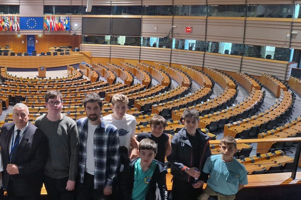 A group of people are standing in front of a large auditorium.